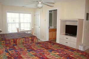 a bedroom with a bed and a flat screen tv at Studio Brunswick Plantation Villa 2404L in Calabash