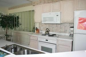 a kitchen with a sink and a stove and a microwave at Brunswick Plantation Resort and Golf Condo 805M with Full Kitchen in Calabash