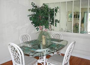 a dining room with a glass table and chairs at Brunswick Plantation Resort and Golf Condo 805M with Full Kitchen in Calabash +27 photos