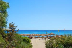 a beach with chairs and umbrellas and the ocean at Corallo Vacanze in Villaputzu