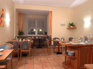 ein Esszimmer mit Tischen und Stühlen sowie ein Esszimmer in der Unterkunft Hotel National in Koblenz