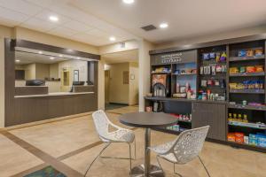 Candlewood Suites Fort Myers/Sanibel Gateway, an IHG Hotel في فورت مايرز: صيدلية مع طاولة وكراسي في الغرفة