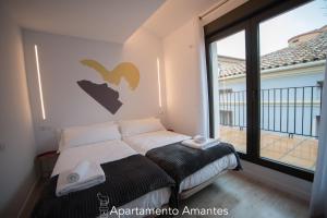 Un dormitorio con una cama y una ventana grande. en Apartamentos Plaza del Torico Teruel, en Teruel