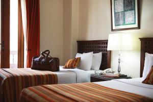 una habitación de hotel con 2 camas y una bolsa en una mesa en San Agustin El Dorado, en Cusco