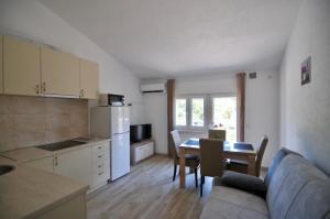 a kitchen and dining room with a table and a couch at NEÐO Apartments Brda in Tivat