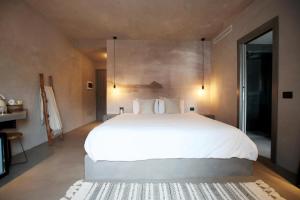 a bedroom with a large white bed and a table at Casa Nostra Boutique Hotel & Spa in Palermo