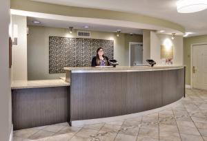 una mujer parada en un mostrador de recepción en el vestíbulo de un hotel en Candlewood Suites Dallas Market Center-Love Field by IHG, en Dallas 29 fotos más