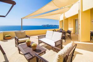 une terrasse avec des chaises et des tables et l'océan dans l'établissement El Toro Vistas al Mar, à El Toro