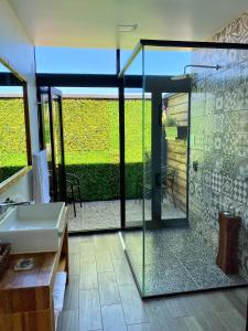 a bathroom with a glass shower and a sink at Xaroma in Valle de Guadalupe