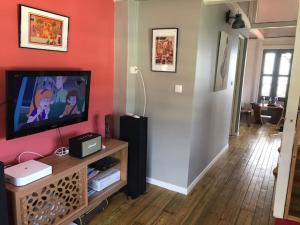 a living room with a flat screen tv on a wall at Habitation Baliache - Maison créole avec jardin privatif, plage à 200m in Deshaies