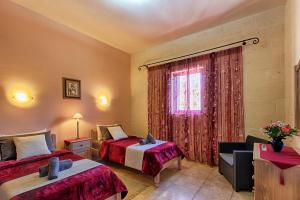 a hotel room with two beds and a window at Ghajn Damma in Xagħra