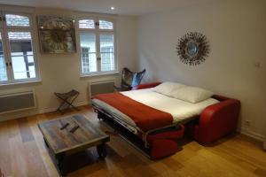 a bedroom with a bed and a table and windows at Appartement Arcade en hyper centre avec parking in Strasbourg