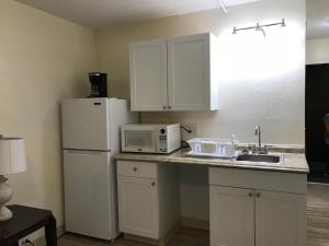 
a kitchen with a refrigerator, sink, microwave, and dishwasher at Hilo Reeds Bay Hotel in Hilo
