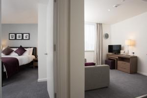 a hotel room with a bed and a television at Staybridge Suites Birmingham by IHG in Birmingham +38 photos