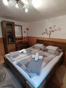 uma cama grande num quarto com um visor de cama grande em Csillag Vendégház em Répáshuta