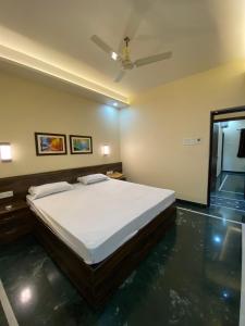 a bedroom with a bed and a ceiling fan at Shivam Hotels in Kolkata