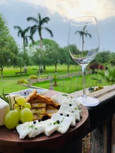 a plate of cheese and grapes and a glass of wine at Casa Hacienda San Jose in Chincha Alta