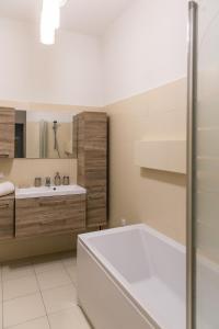 La salle de bains est pourvue d'une baignoire et d'un lavabo. dans l'établissement Apartament Poznańska, à Varsovie
