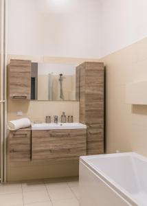 La salle de bains est pourvue d'un lavabo, d'un miroir et d'une baignoire. dans l'établissement Apartament Poznańska, à Varsovie