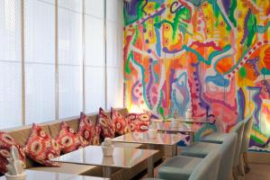 a dining room with tables and a colorful wall at Hôtel Mayet in Paris