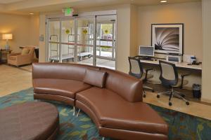 ein Büro mit einem Ledersofa und einem Schreibtisch mit einem Computer in der Unterkunft Candlewood Suites Eugene Springfield, an IHG Hotel in Eugene