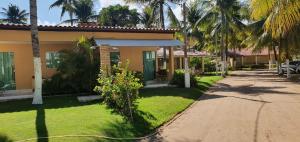 马拉戈日Condomínio Village, Casa Cecília的一座带花园和车道的房子