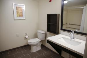 a bathroom with a toilet and a sink and a mirror at Candlewood Suites - Portland - Scarborough by IHG in Scarborough +21 photos