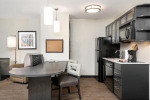 a kitchen and dining room with a table and chairs at Candlewood Suites Durham - RTP by IHG in Durham