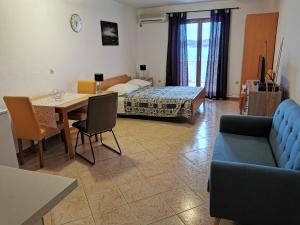 a living room with a couch and a table and a bed at Apartmani Prova 4 in Tisno