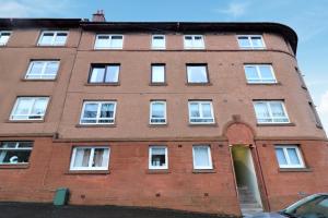 a red brick building with white windows and a door at Greenock West Apartment in Greenock