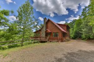 a log cabin in the woods with a fence at CABIN TIME - When you need to relax and unwind a visit to Cabin Time is what you need! in Mineral Bluff