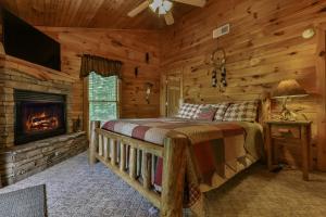 um quarto com uma cama e uma lareira num chalé de madeira em CABIN TIME - When you need to relax and unwind a visit to Cabin Time is what you need! em Mineral Bluff