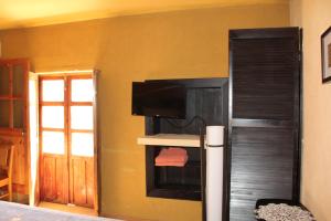 a room with a tv on a wall at Hotel Plaza Mayor in Tlalpujahua de Rayón