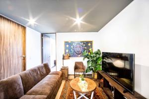 ein Wohnzimmer mit einem Sofa und einem Tisch in der Unterkunft Modern & Renovated Apartment with Private Patio in Tacuba - Legaria in Mexiko-Stadt