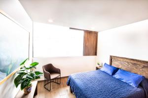 - une chambre avec un lit, une chaise et une fenêtre dans l'établissement Modern & Renovated Apartment with Private Patio in Tacuba - Legaria, à Mexico