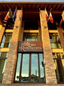 una señal en la parte delantera de un edificio con banderas en Sole della Franciacorta - Hotel & Restaurant, en Capriolo