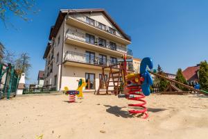 a playground in the sand in front of a building at Adamar Jastrzębia Góra in Jastrzębia Góra