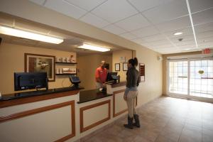 a woman standing at a counter in a waiting room at Candlewood Suites Richmond Airport, an IHG Hotel in Sandston