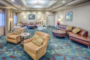 a waiting room with couches and chairs and tables at Candlewood Suites Fargo-North Dakota State University by IHG in Fargo