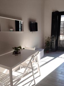 una mesa blanca y sillas en la sala de estar. en APARTAMENTO CENTRO SANTA CATALINA, en Sevilla