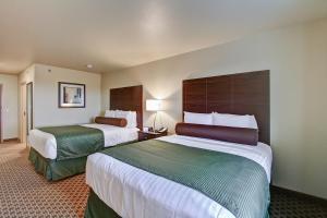 a hotel room with two beds in a room at Cobblestone Hotel & Suites Pulaski/Green Bay in Pulaski