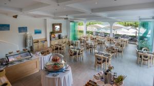 a restaurant with tables and chairs in a room at Hotel Porto Koufo in Porto Koufo