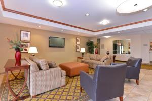 a living room with furniture and a flat screen tv at Candlewood Suites Elmira Horseheads by IHG in Horseheads