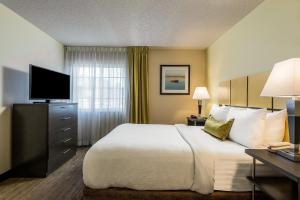 a hotel room with a large bed and a television at Candlewood Suites Richmond West End Short Pump, an IHG Hotel in Short Pump