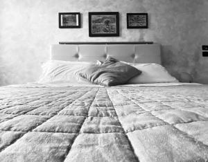 a bedroom with a large white bed with two pictures on the wall at Sole della Franciacorta - Hotel & Restaurant in Capriolo