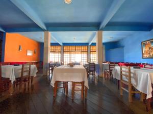 a dining room with tables and chairs and blue ceilings at Hotel dos Sonhos in São Thomé das Letras