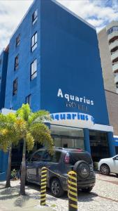 a car parked in front of a blue building at Hotel Aquarius in Fortaleza