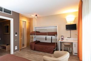 ein Hotelzimmer mit einem Etagenbett und einem Schreibtisch in der Unterkunft Hotel Donatello Imola in Imola
