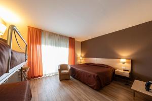 a hotel room with a bed and a window at Hotel Donatello Imola in Imola