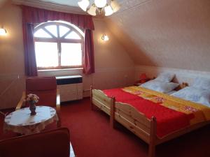 a bedroom with two beds and a window at Zsoli Vendégház in Alsópáhok